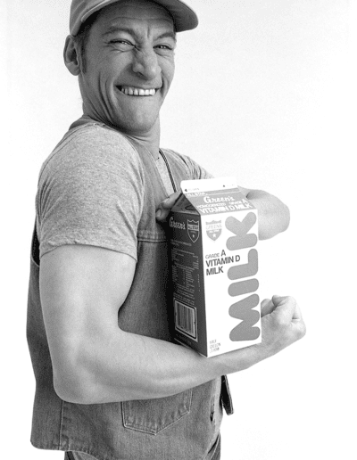 Ernest in Green's Milk ad, flexing muscle