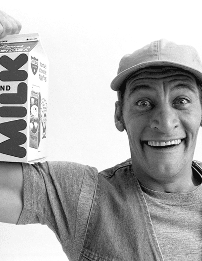 Ernest in Green's Milk ad, flexing muscle
